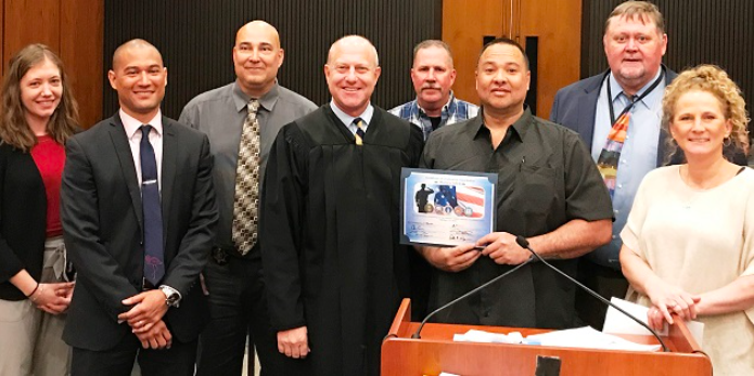 Program graduate photo with a judge and court staff
