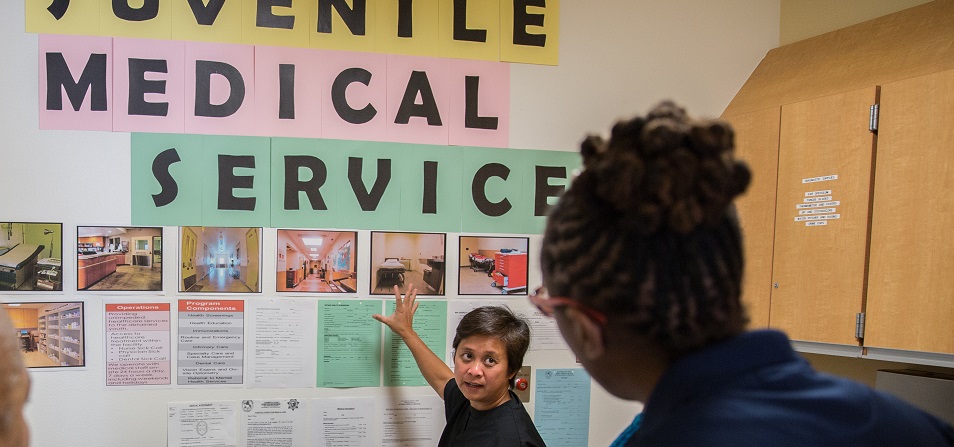 Lady pointing at a wall of pictures during orientation night